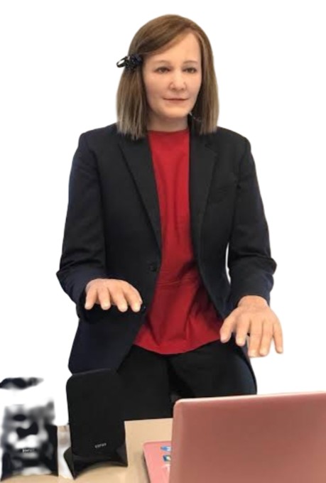 a woman sitting at a desk with her hands out
